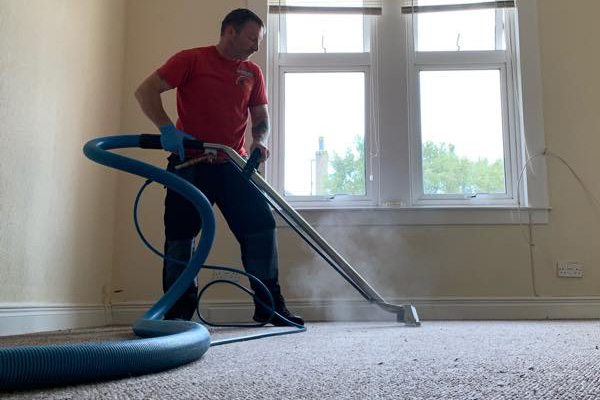 Alex steam cleaning a carpet